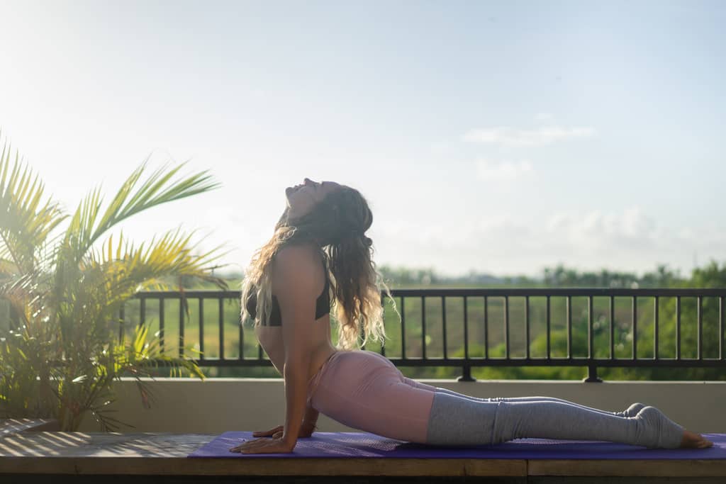 mujer haciendo yoga en terraza